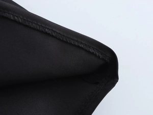 Detailed close-up of fabric texture and fine stitching on a black elegant floral dress