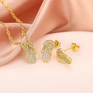 Gedetailleerd beeld van een goudkleurige ketting met slipper hanger en zirkoon op roze zijde