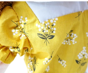 Close-up of yellow fabric with white floral patterns and cotton texture on hand puppet