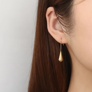 French vintage golden waterdrop earrings in titanium steel worn by model with clean white background