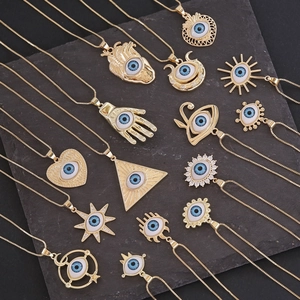 Collection de colliers oeil bleu en or avec pendentifs main de Fatma sur fond sombre