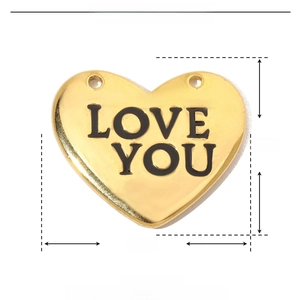 Dettaglio macro del ciondolo a cuore in acciaio dorato con incisione Love You e misure