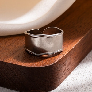 Detailed macro shot of silver wavy wide band ring with a matte brushed metal finish