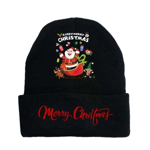 Detail of black knit beanie with Merry Christmas text and festive reindeer patterns