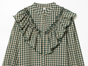 Detailed view of plaid long sleeve shirt with tiered ruffles and S-size collar label