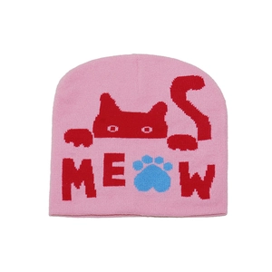 Close-up of pink knit beanie featuring a red cat pattern and blue paw print embroidery