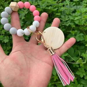 Pink and grey silicone bead keychain bracelet with wooden disc and leather tassel decoration