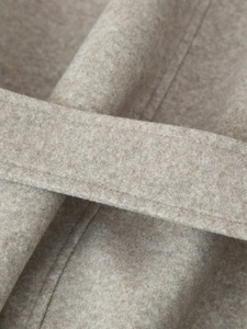 Macro shot of beige wool blend fabric texture and stitching details of the coat belt