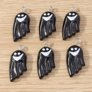 Detail view of glossy black ghost charms with white smiley faces for Halloween jewelry DIY
