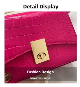 Macro view of magenta faux crocodile leather handbag with golden metal twist lock