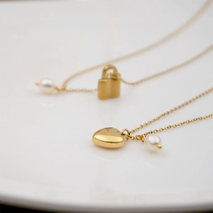 Collier élégant en titane doré avec pendentifs cœur et cadenas et perles pour femme