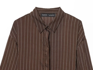 Detail of striped shirt collar and dark brown buttons with precise stitching on fabric