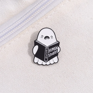 Detailed close-up of a cartoon ghost reading a Human Stories book enamel pin on canvas