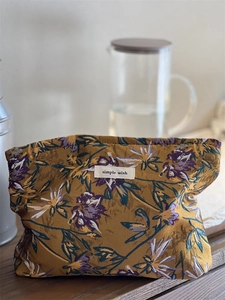 Close-up of caramel jacquard floral makeup bag fabric with simple wish woven label
