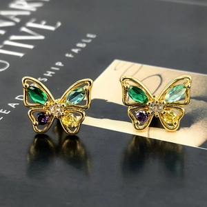 Elegant gold butterfly stud earrings with colorful zircon stones on dark surface