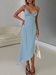 Light blue embroidered slip dress with V-neck and irregular slit hem in a minimalist setting