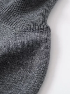 Detailed macro view of dark grey ribbed knit sweater collar and smooth seam stitching