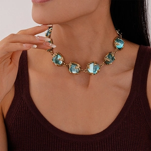 Close-up of vintage gold chain necklace with large translucent blue resin stones