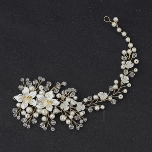 Detail of handcrafted bridal headband with crystal flowers and white pearls on gold wire
