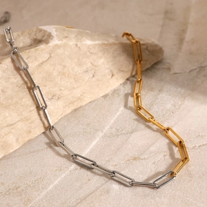 Macro detail of two-tone paperclip chain necklace in polished gold and silver finish