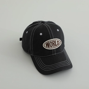 Detail of black washed denim baseball cap with white contrast stitching and WORLD patch