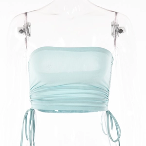 Détail du haut bandeau en maille côtelée bleu clair avec cordons latéraux et fronces