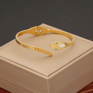 Elegant gold snake-shaped stainless steel bangle with green eyes and white zircons