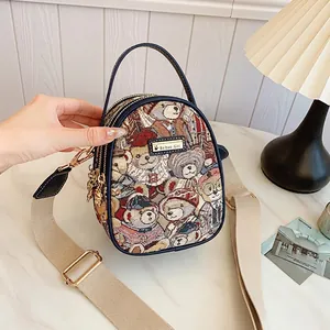 Chic bear pattern jacquard handbag with navy leather trim and wide crossbody strap