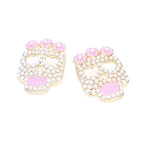 Exaggerated skull earrings with pearls and pink enamel flowers on gold alloy base