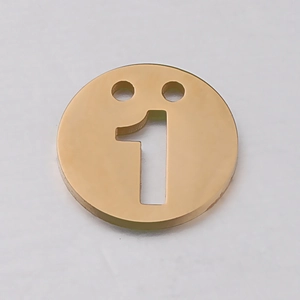 Vue macro d'un pendentif chiffre 1 en acier inoxydable doré mat avec double perforation