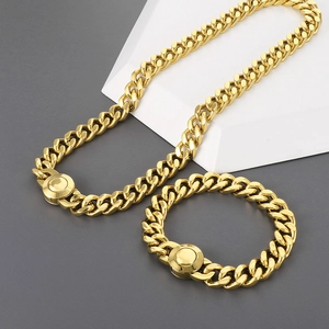 Detail of 11mm gold Cuban link necklace and bracelet set with round clasp on geometric background