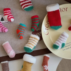 Detailed view of colorful mini knitted Christmas socks for festive DIY decoration and crafts