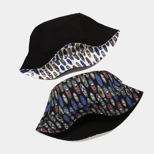 Double-sided cotton bucket hat featuring a colorful surfboard print and solid black side
