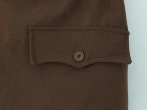 Détail d'une jupe marron foncé en laine mélangée avec poche à rabat boutonnée