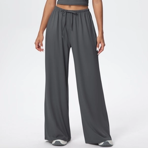 Detail of drawstring waistband and drape effect on dark grey wide-leg trousers