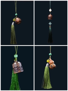 Detailed view of carved sandalwood pendants with silk tassels and auspicious inscriptions