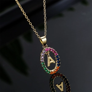 Gold plated initial A necklace with colorful zircon oval pendant on black background