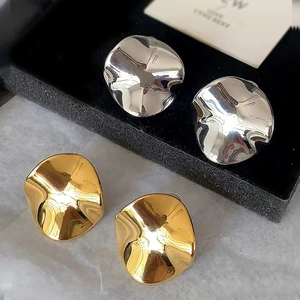 Minimalist gold and silver irregular round stud earrings with polished metallic finish