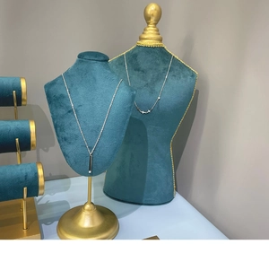 Détail de pendentifs étoile et barre argentée sur supports en velours bleu avec éclairage