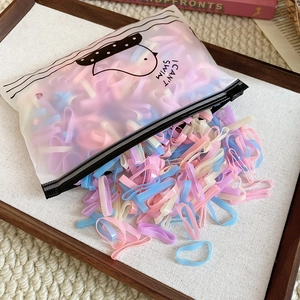 Macro shot of colorful macaron elastic hair bands scattered in a matte zipper bag