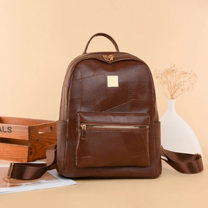 Macro shot of dark brown pebbled leather texture with elegant gold hardware on backpack