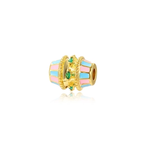 Macro shot of gold barrel bead with pink enamel stripes and green zircon marquise stones