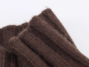 Detailed close-up of dark brown ribbed knit fabric showing soft wool texture and fibers