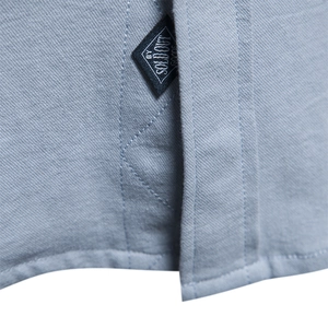 Macro detail of twill cotton shirt fabric in grey-blue with black brand label