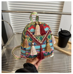 Detail of national style mini backpack with vibrant colorful tassels and woven texture