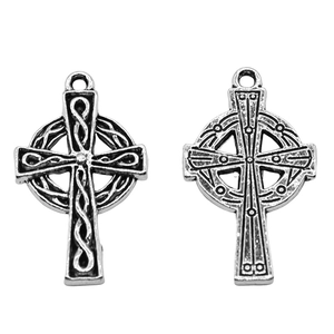 Antique silver Celtic cross pendants with intricate knotwork patterns on white background