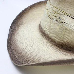Détail du chapeau de cowboy en paille tressée avec bord dégradé et couronne aérée