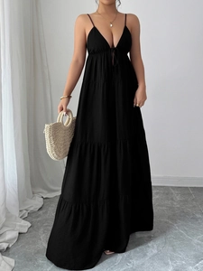 Detail of elegant black V-neck tiered maxi dress with high-quality textured fabric
