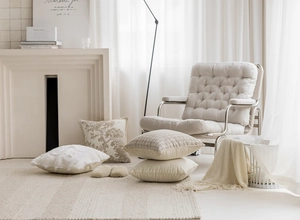 Cozy home setup with beige velvet cushions and soft knit throw on a modern armchair