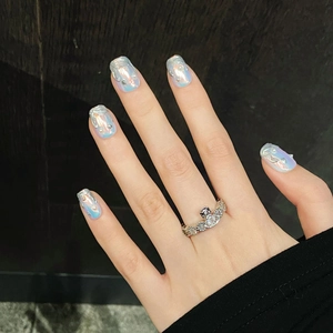 Nahaufnahme eines silbernen Punk-Rings mit Saturn-Design und funkelnden Strasssteinen